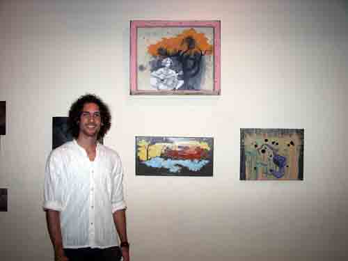 Artist, Stefan Kietzman with his paintings in the gallery at Studio 34.